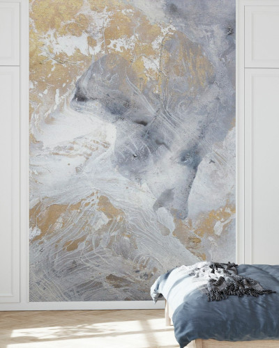 Tapet modern cu design abstract, cu nuanțe de aur și gri, în stil minimalist, decorat pe un perete din dormitor, lângă un pat cu lenjerie gri și o noptieră cu o lampă.