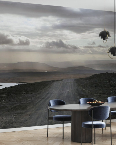 A wallpaper with a scenic view of a winding road in a desolate landscape under a cloudy sky.