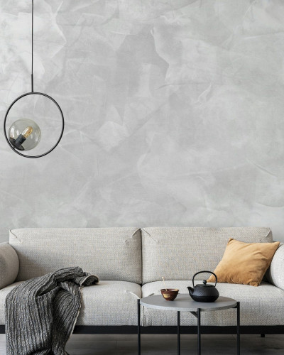 Tapet Mineral Matter gri deschis, cu aspect de beton, in living, cu canapea, masa, si accesorii decorative