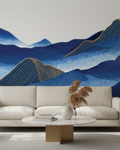 Fototapet personalizat cu munți albaștri abstracți și linii aurii, instalat într-un living modern cu o canapea bej, fotolii și plante verzi, creând o atmosferă elegantă și senină.