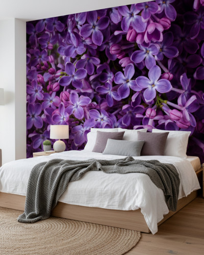 Fototapet cu flori de liliac mov intens pe peretele unui dormitor modern. Patul alb și mobilierul din lemn completează decorul relaxant.