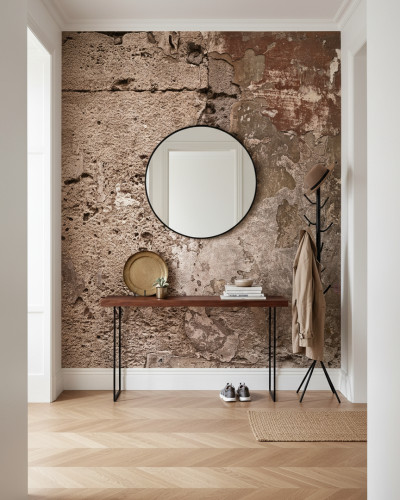 Hol modern cu tapet personalizat Urban Patchwork Canvas, ce imită zidărie veche deteriorată. Pe perete un tapet cu textură rustică, o masă consolă din lemn cu oglindă rotundă, cuier negru cu haină și pălărie. Parchet tip chevron.