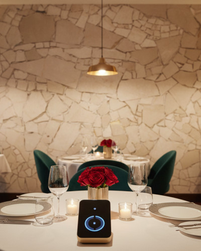 Fototapet personalizat Urban Glass Shard într-un restaurant elegant, cu pereți texturati deschiși la culoare și mese aranjate.