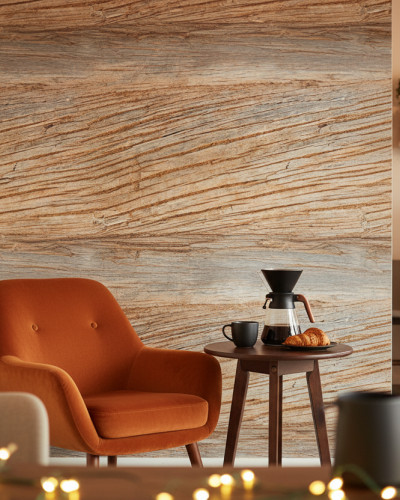 Tapet personalizat Desert Relic Drift cu textură de lemn vechi pe un perete accent. Un fotoliu portocaliu și o măsuță cu cafea creează o atmosferă caldă și primitoare într-un spațiu de living modern.