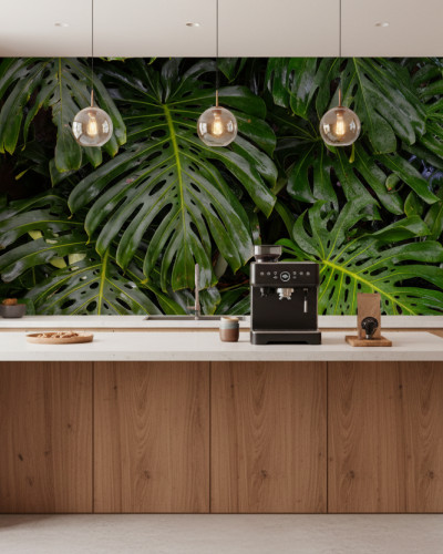 Fototapet personalizat Monstera Split Serenity într-o bucătărie modernă cu insulă albă, mobilier din lemn deschis și scaune de bar. Peretele din spate este acoperit cu un fototapet vibrant cu frunze mari de Monstera, creând o atmosferă tropicală și proasp