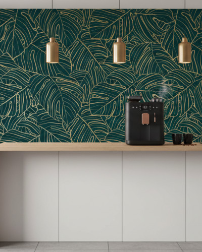 Tapet personalizat cu model tropical de frunze aurii pe fundal verde smarald într-o bucătărie modernă, cu insulă albă și corpuri de iluminat aurii.