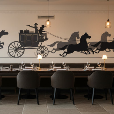 Fototapet personalizat cu siluete de călăreți pe cai și o trăsură, ilustrând o scenă de urmărire din Vestul Sălbatic, pe peretele unui restaurant modern.