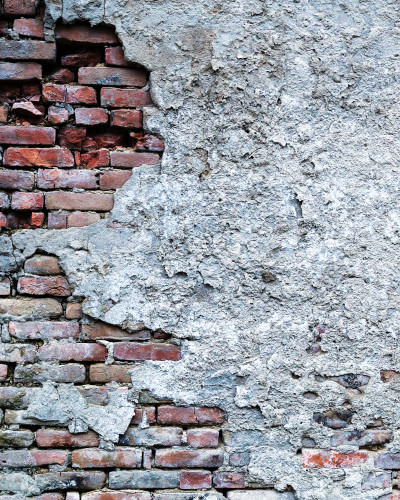 Fototapet personalizat Heritage Brick Patina, reprezentând un perete cu zidărie veche expusă și tencuială gri deteriorată, într-un decor interior cu oglindă rotundă și masă consolă.