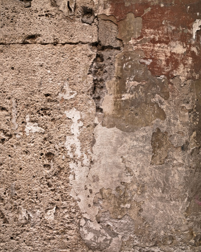 Hol modern cu tapet personalizat Urban Patchwork Canvas, ce imită zidărie veche deteriorată. Pe perete un tapet cu textură rustică, o masă consolă din lemn cu oglindă rotundă, cuier negru cu haină și pălărie. Parchet tip chevron.