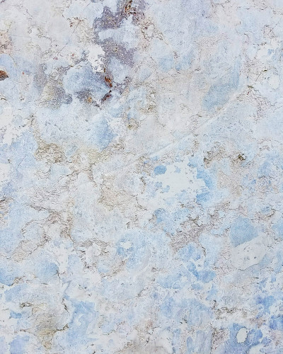 Perete cu fototapet Ancient Stone Patina, cu textură de piatră veche în nuanțe de albastru-gri, într-un hol modern cu consolă neagră, oglindă ovală și lampadar auriu.