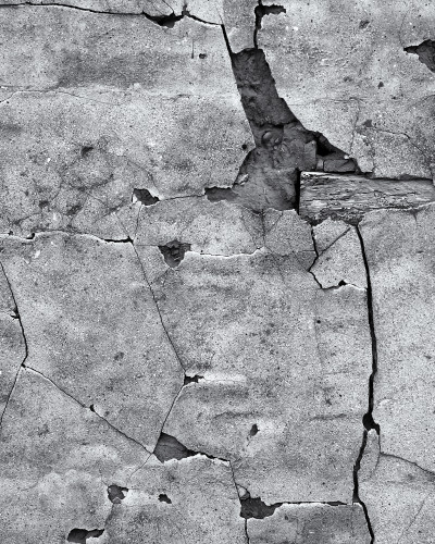 Fototapet Urban Fracture cu efect de beton crăpat gri pe peretele unui hol modern. Prezintă o consolă, oglindă rotundă și podea din lemn deschis.